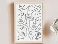 Tableau abstrait visage, une composition de visages stylisés en lignes continues noires sur fond blanc, dans un cadre en bois clair.