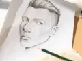 Un portrait au crayon, étape d'un tuto dessin réaliste. Le regard intense et la coiffure sont particulièrement réussis.