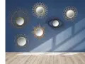 Collection de miroirs décoratifs, dont un œil stylisé, dans un esprit **metal art déco**, sur fond bleu.
