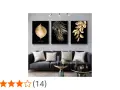 Un salon moderne avec un canapé gris, des coussins décoratifs et un triptyque **tableau noir et or** de feuilles dorées sur fond noir.