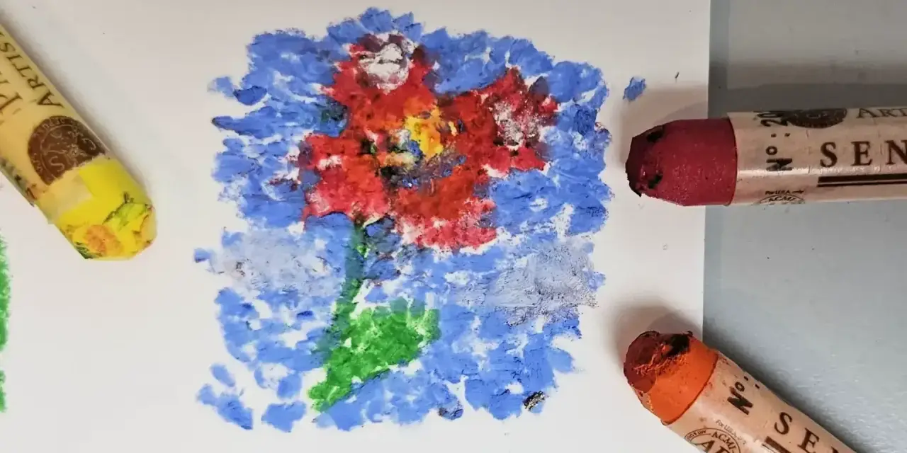 Apprenez comment utiliser les pastels à l'huile pour créer une fleur vibrante sur fond bleu. Des pastels jaune, rouge et orange sont visibles.