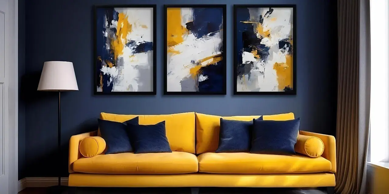 Un salon moderne avec un canapé jaune vif, des coussins bleus et trois tableaux abstraits aux teintes bleu et jaune.