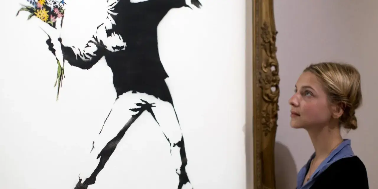 Une jeune femme admire "Flower Thrower", une œuvre emblématique de qui est Banksy, représentant un homme lançant un bouquet de fleurs.