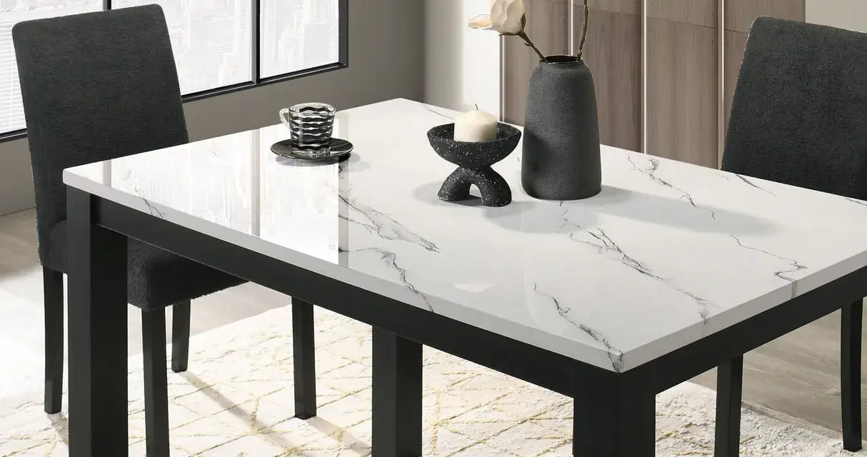 Table à manger moderne avec plateau marbre blanc et noir, chaises sombres et vase.
