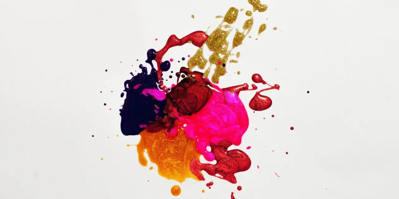 Projection peinture : éclaboussures de vernis à ongles aux couleurs vives et métalliques, créant une œuvre abstraite et dynamique.