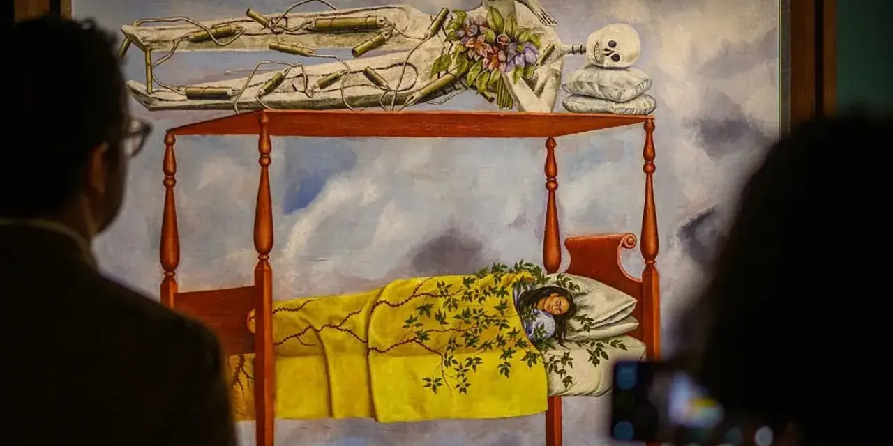 La peinture de Frida Kahlo "Le lit volant" montre une femme endormie sous une couverture jaune, avec un squelette au-dessus.