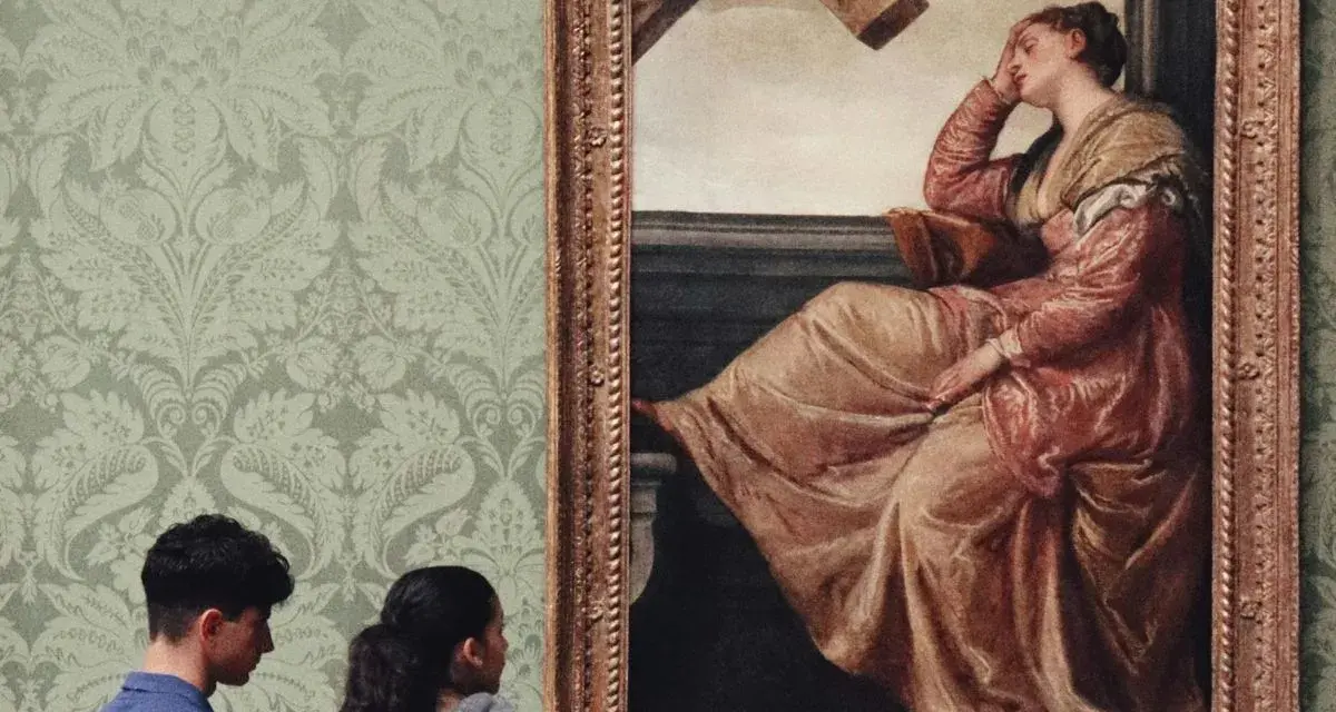 Deux visiteurs contemplent un tableau célèbre, une femme en robe rose, dans une galerie d'art aux murs tapissés.
