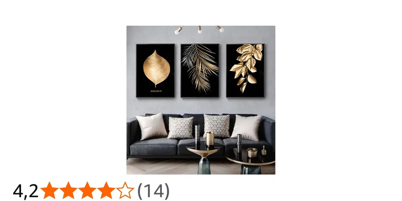 Un salon moderne avec un canapé gris, des coussins décoratifs et un triptyque **tableau noir et or** de feuilles dorées sur fond noir.