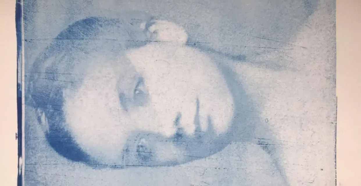 Portrait d'une personne en gros plan, réalisé par transfert photo sur gelli plate. L'image est en tons bleus, avec des textures et des lignes visibles.