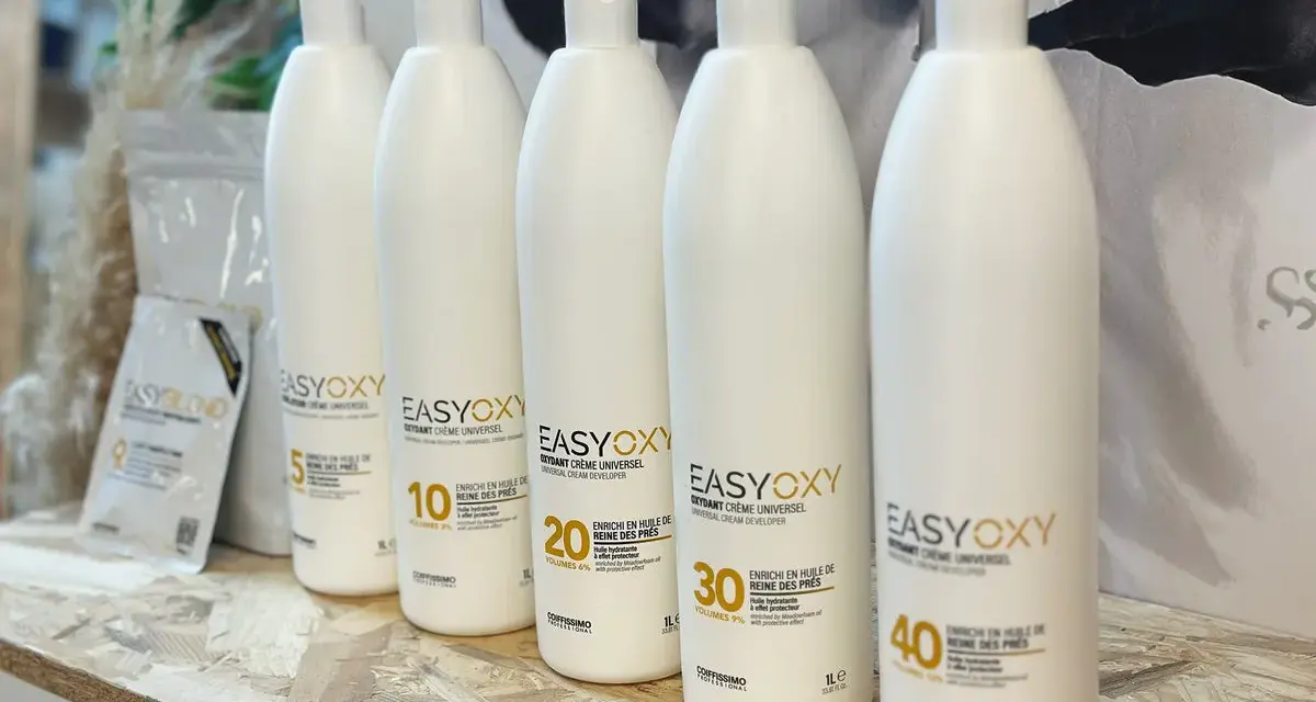 Cinq bouteilles d'oxydant EasyOxy, aux teintes gris marron sur l'étiquette, alignées sur une étagère en bois.