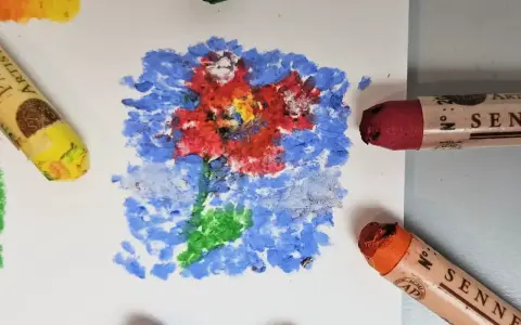 Apprenez comment utiliser les pastels à l'huile pour créer une fleur vibrante sur fond bleu. Des pastels jaune, rouge et orange sont visibles.