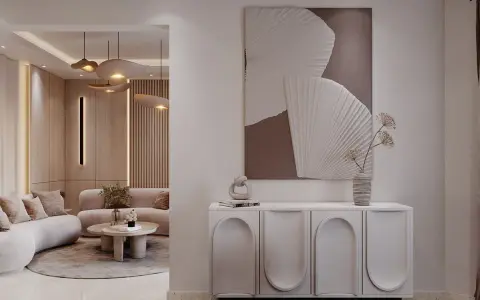 Un tableau marron beige abstrait orne un mur au-dessus d'un buffet moderne. Le salon adjacent est baigné de lumière douce.