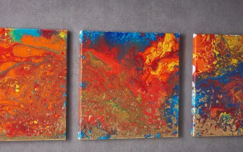 Trois toiles abstraites aux couleurs vives, un exemple de pouring art, avec des touches dorées.