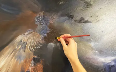 Main d'artiste travaillant sur une peinture à l'huile technique, ajoutant des détails à une figure aux ailes majestueuses.