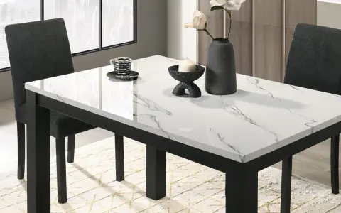 Table à manger moderne avec plateau marbre blanc et noir, chaises sombres et vase.