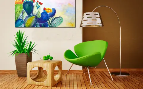 Un tableau cactus moderne aux couleurs vives, avec des touches de bleu, vert et jaune, illumine un salon contemporain.