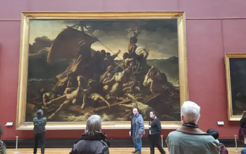 Un tableau crépuscule, "Le Radeau de la Méduse", montre des survivants désespérés sur un radeau. Des visiteurs contemplent cette œuvre dramatique.