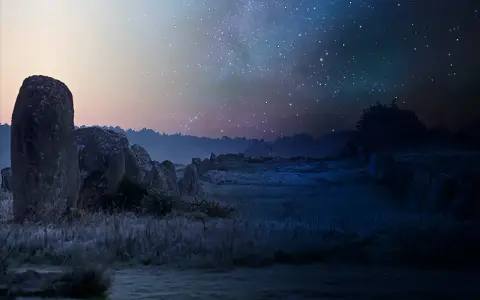 Mégalithes sous un ciel étoilé, une peinture lumineuse la nuit. L'herbe givrée reflète la douce lueur du ciel, créant une atmosphère mystique.