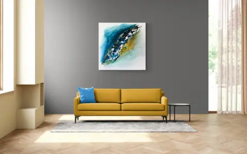 Un tableau grand format abstrait aux tons bleus et dorés domine un salon moderne. Un canapé jaune vif et un coussin bleu apportent une touche de couleur.