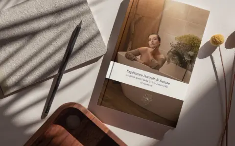 Un livre "Expérience Portrait de femme" est posé près d'un carnet et d'un crayon, suggérant comment dessiner un portrait à partir d'une photo pour capturer l'essence d'un moment.