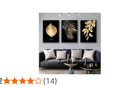 Un salon moderne avec un canapé gris, des coussins décoratifs et un triptyque **tableau noir et or** de feuilles dorées sur fond noir.