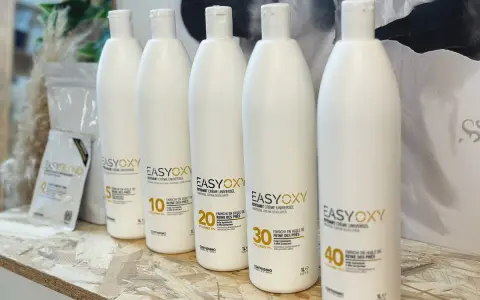 Cinq bouteilles d'oxydant EasyOxy, aux teintes gris marron sur l'étiquette, alignées sur une étagère en bois.
