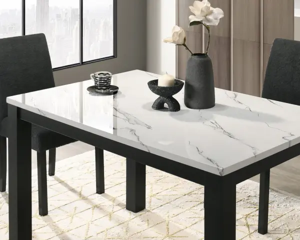 Table à manger moderne avec plateau marbre blanc et noir, chaises sombres et vase.