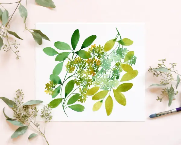Un dessin à l'aquarelle de feuilles d'eucalyptus vertes et jaunes sur du papier blanc, entouré de vraies branches d'eucalyptus.