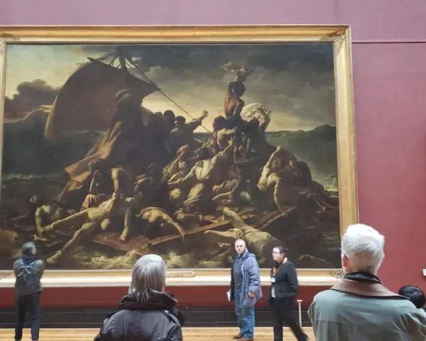 Un tableau crépuscule, "Le Radeau de la Méduse", montre des survivants désespérés sur un radeau. Des visiteurs contemplent cette œuvre dramatique.