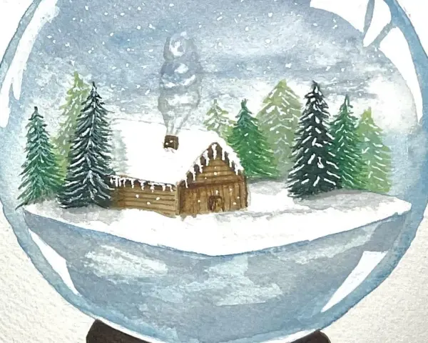 Une boule de noël aquarelle dépeint une scène hivernale avec une cabane en bois enneigée, des sapins et de la fumée s'échappant de la cheminée.