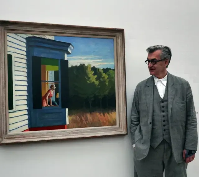 Un homme regarde une peinture d'Edward Hopper, "Gas", représentant une femme à une fenêtre.