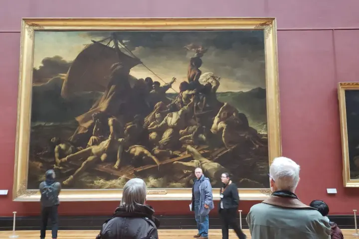 Un tableau crépuscule, "Le Radeau de la Méduse", montre des survivants désespérés sur un radeau. Des visiteurs contemplent cette œuvre dramatique.