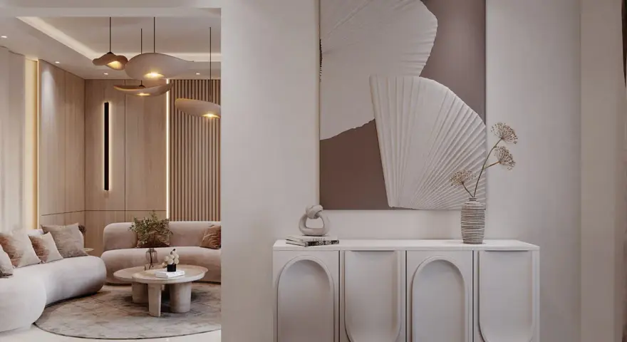Un tableau marron beige abstrait orne un mur au-dessus d'un buffet moderne. Le salon adjacent est baigné de lumière douce.