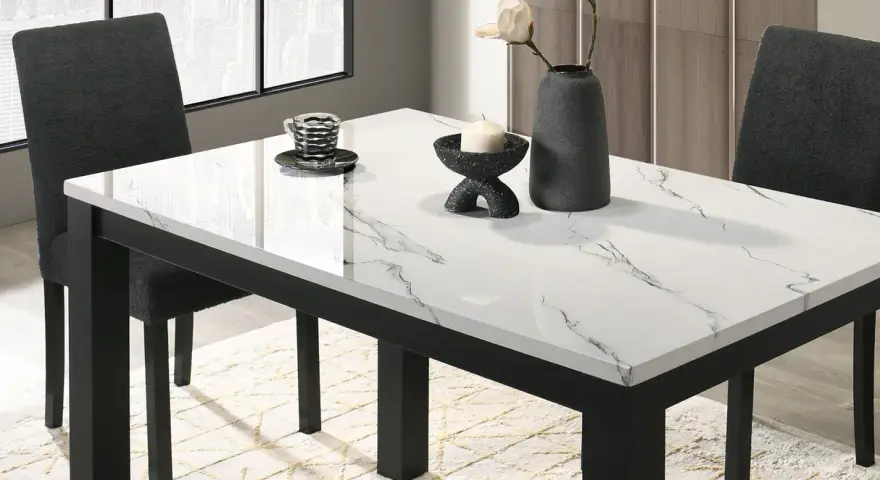 Table à manger moderne avec plateau marbre blanc et noir, chaises sombres et vase.
