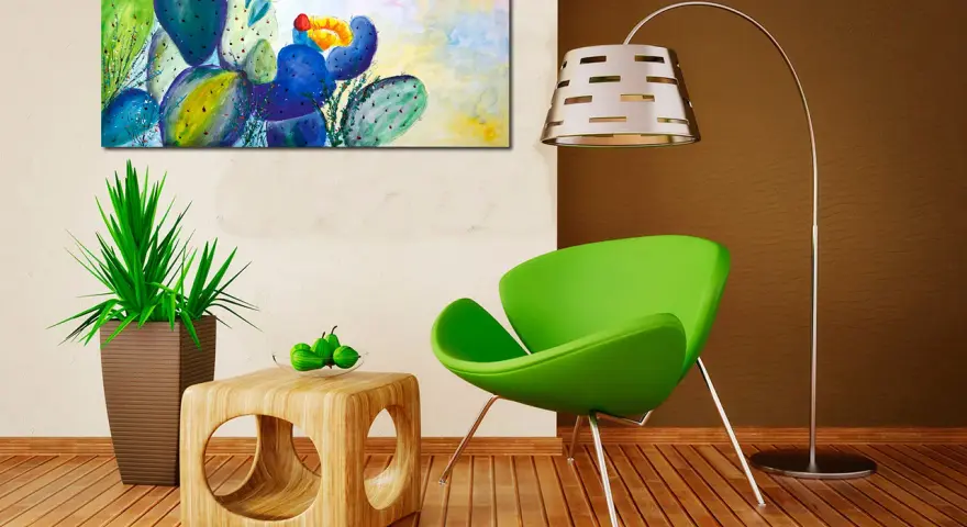 Un tableau cactus moderne aux couleurs vives, avec des touches de bleu, vert et jaune, illumine un salon contemporain.