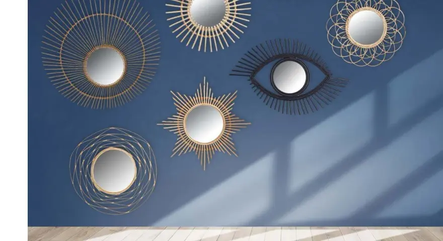 Collection de miroirs décoratifs, dont un œil stylisé, dans un esprit **metal art déco**, sur fond bleu.