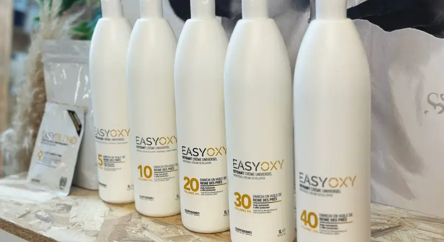 Cinq bouteilles d'oxydant EasyOxy, aux teintes gris marron sur l'étiquette, alignées sur une étagère en bois.