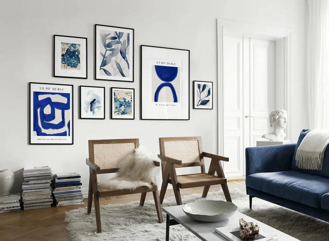 Un salon moderne avec un tableau bleu et blanc abstrait, des chaises en rotin et un canapé bleu.