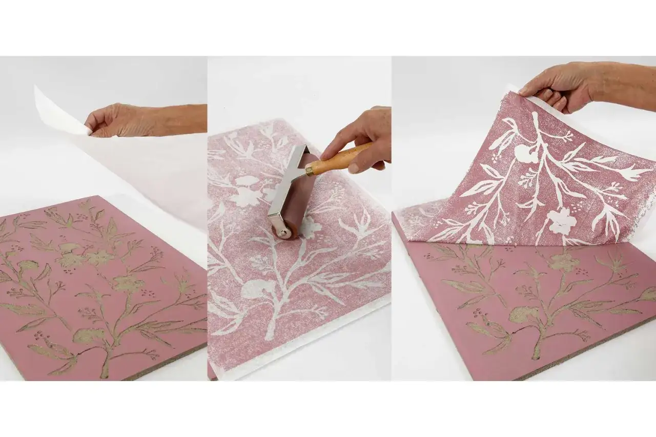 Application d'un motif floral sur un papier linogravure &agrave; l'aide d'un rouleau. Le r&eacute;sultat est un papier d&eacute;coratif aux teintes douces.