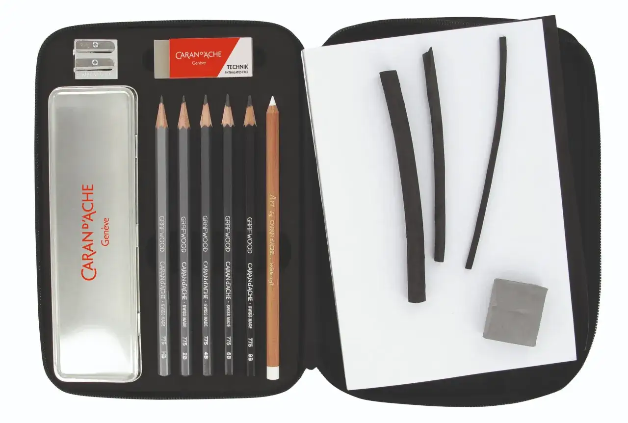 &Eacute;tui ouvert r&eacute;v&eacute;lant un mat&eacute;riel de dessin liste : crayons, fusains, gomme, taille-crayon et bo&icirc;te m&eacute;tallique Caran d'Ache.