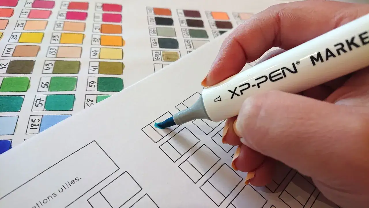 Main d'une personne utilisant un marqueur bleu sur une feuille de tests de couleurs, id&eacute;ale pour le papier pour feutre alcool.