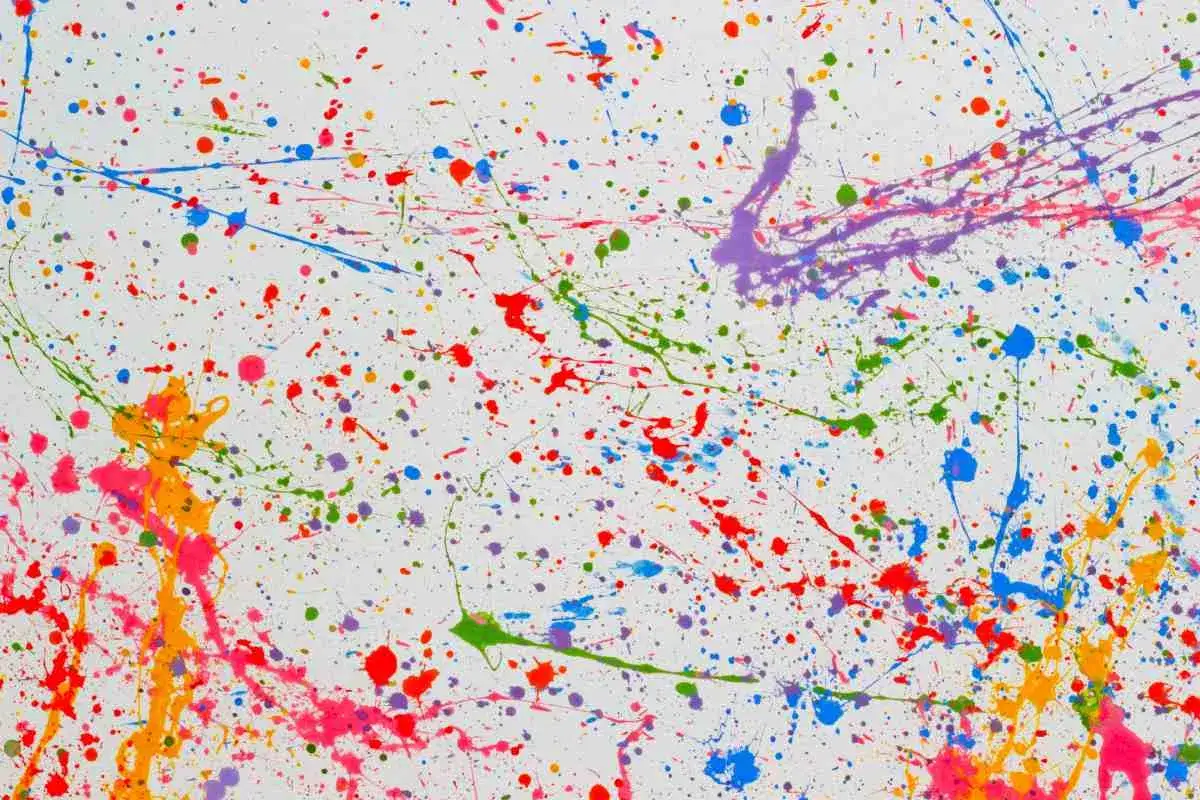 Explosion de couleurs vives sur fond blanc, une projection peinture joyeuse et dynamique.