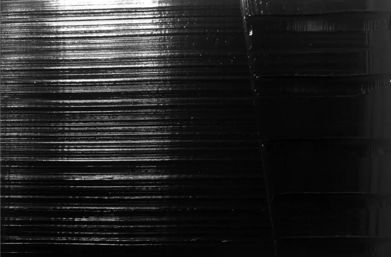 Texture de peinture noir absolu, avec des lignes horizontales fines et des blocs plus &eacute;pais sur la droite.